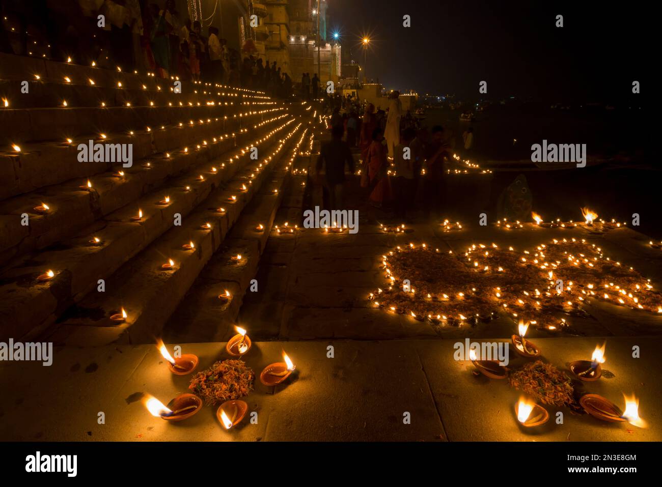 La gente si riunisce ai ghati di Varanasi per Dev Deepawali con candele accese di notte per celebrare la festa di Kartik Poornima Foto Stock