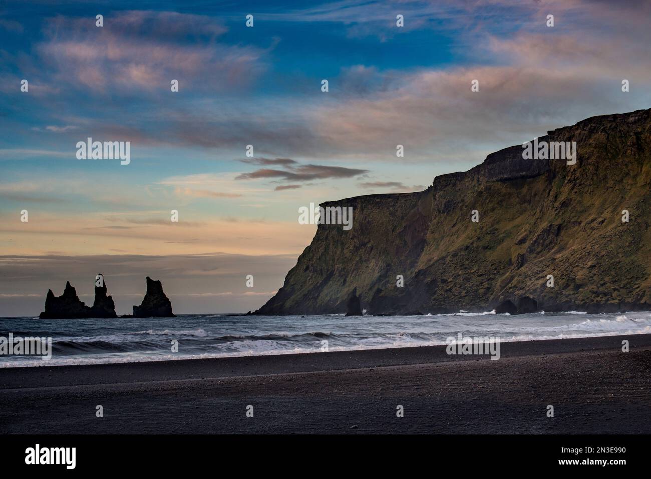 Vista delle scogliere e della spiaggia nera, Reynisfjara Beach, sulla costa meridionale dell'Islanda, vicino alla città di Vik, al crepuscolo; Islanda Foto Stock