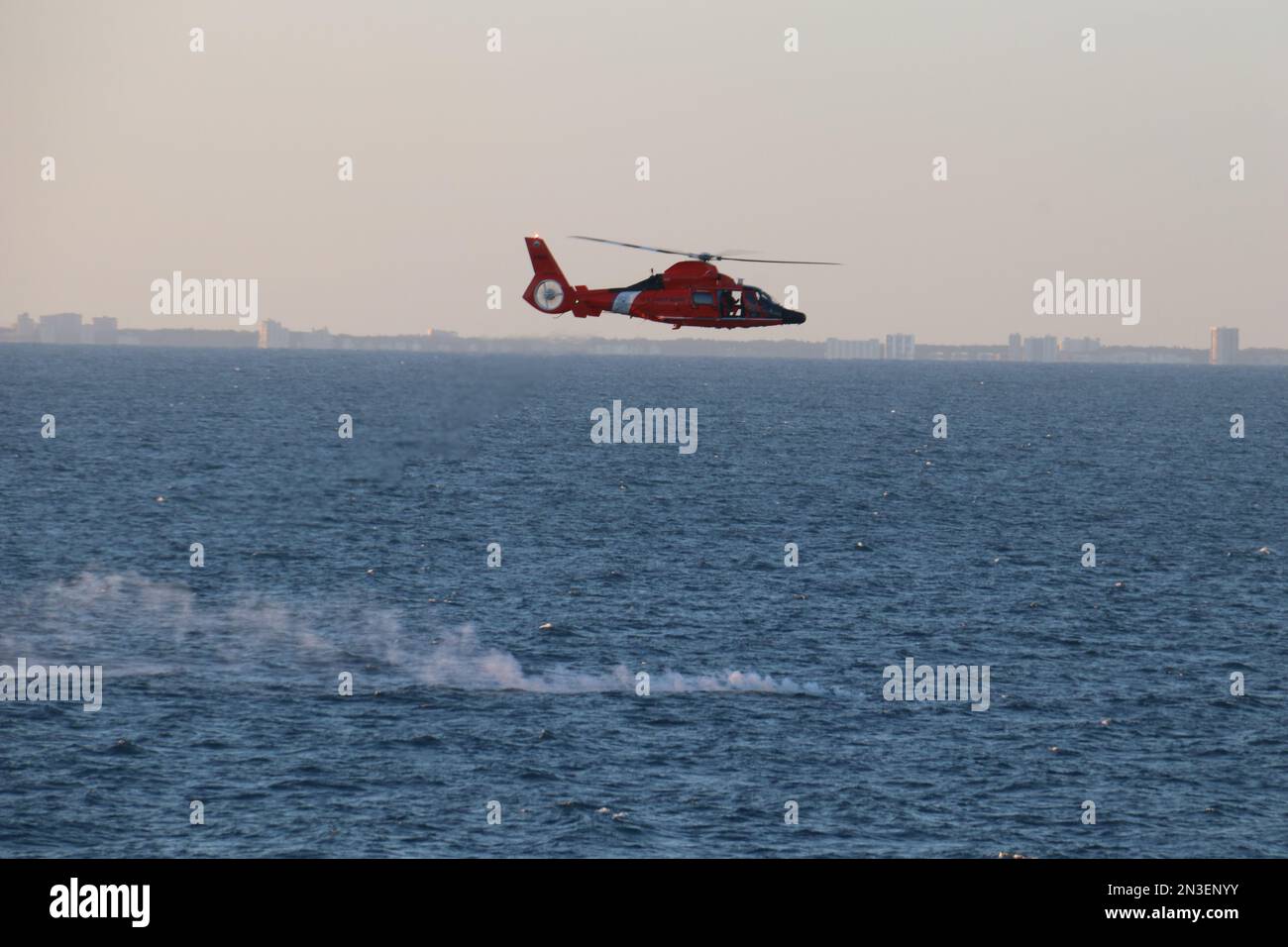 Myrtle Beach, Stati Uniti d'America. 04 febbraio, 2023. Un elicottero della Guardia Costiera degli Stati Uniti MH-65 Dolphin sorvola il campo di detriti della mongolfiera cinese di sorveglianza ad alta quota mentre le operazioni di recupero iniziano sull'Oceano Atlantico, il 4 febbraio 2023 al largo della costa di Myrtle Beach, South Carolina. Il sospettato pallone spia è stato abbattuto da un aereo da combattimento americano il 4th febbraio dopo aver viaggiato attraverso gli Stati Uniti continentali. Credit: Lt. Jerry Ireland/US Navy Photo/Alamy Live News Foto Stock
