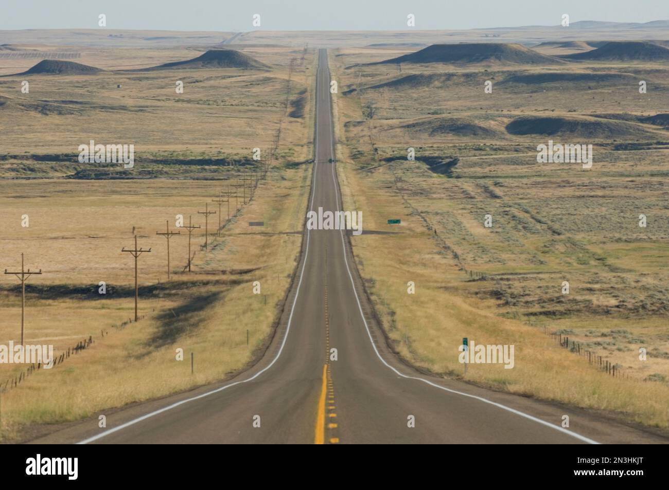 Strada di campagna vuota a due corsie che si dirige direttamente in lontananza nella campagna del Montana; Billings, Montana, Stati Uniti d'America Foto Stock