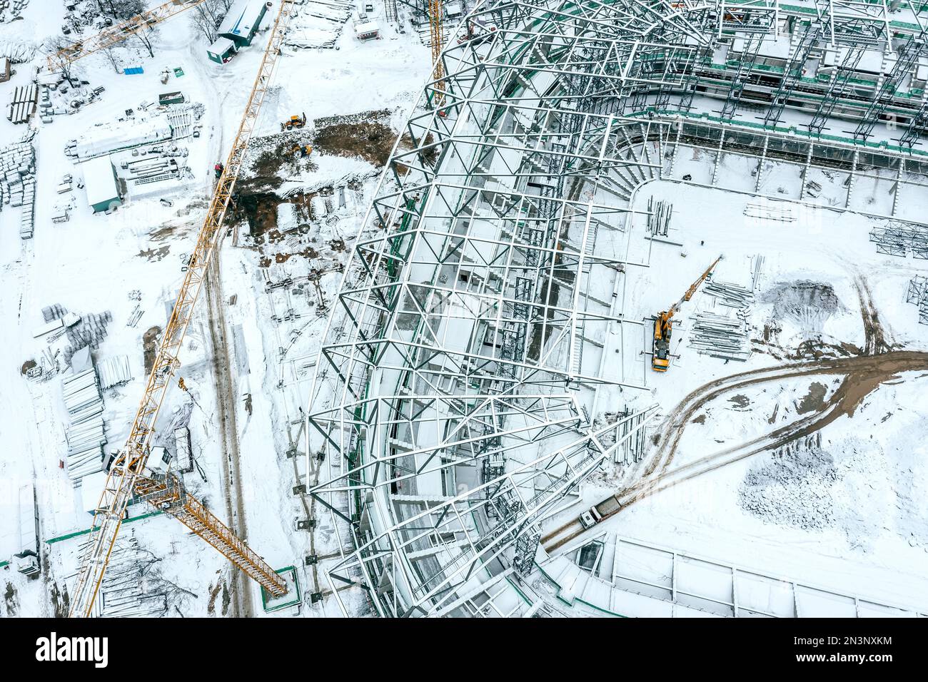 vista aerea dall'alto del cantiere, coperta di neve con gru gialla. nuovo stadio in costruzione. Foto Stock
