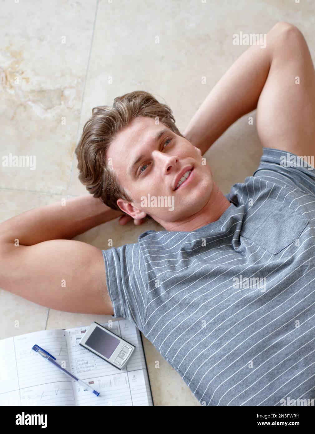Respirando... un giovane uomo dall'aspetto rilassato che giace sul pavimento. Foto Stock