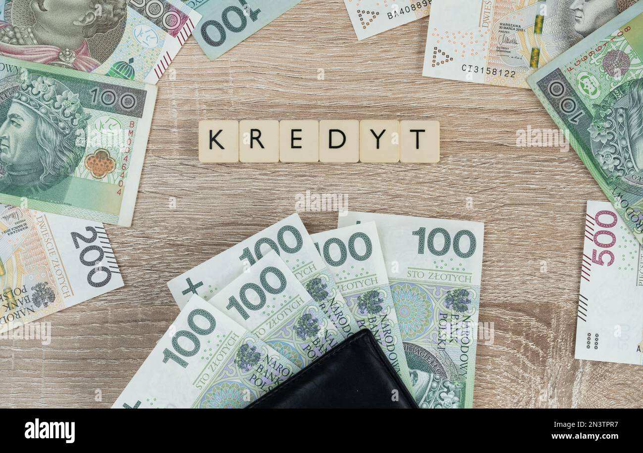 Kredyt in lingua polacca significa prestito o ipoteca. Acquistare una casa o un appartamento in Polonia. Composizione a giacimento piatto con denaro złoty, banconote PLN zloty. Foto Stock