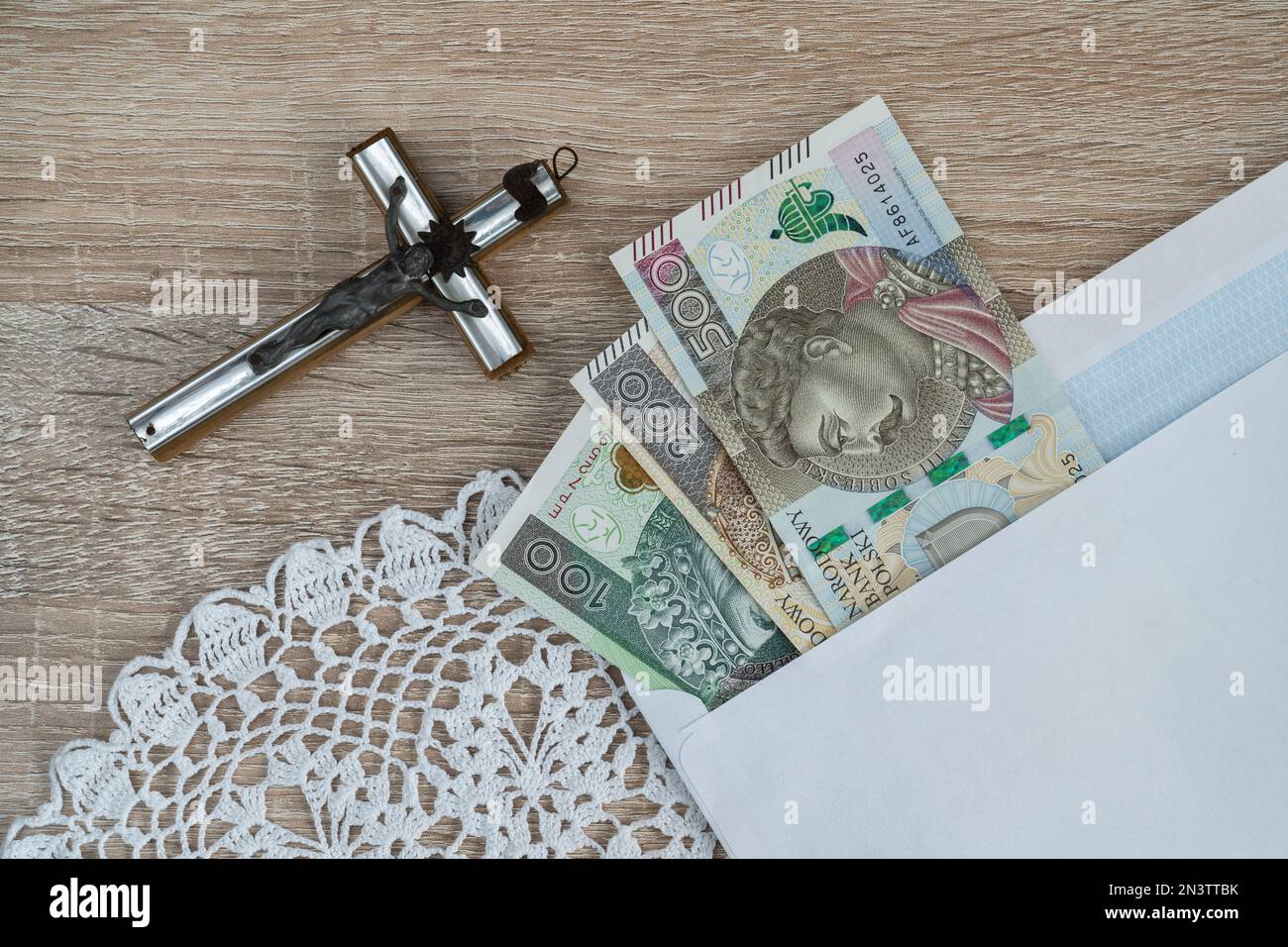 Visita Pastorale o Kolęda, tradizione cattolica dopo Natale in Polonia. Croce e busta con denaro polacco per sacerdote. Koleda donazione per la chiesa. Foto Stock