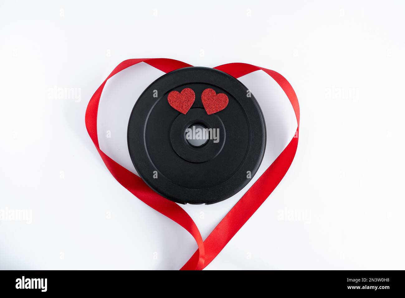 Gym manubri piatto di pesi barbell e nastro rosso a forma di cuore. Regalo  d'amore per San Valentino, fidanzamento, anniversario, matrimonio Foto  stock - Alamy