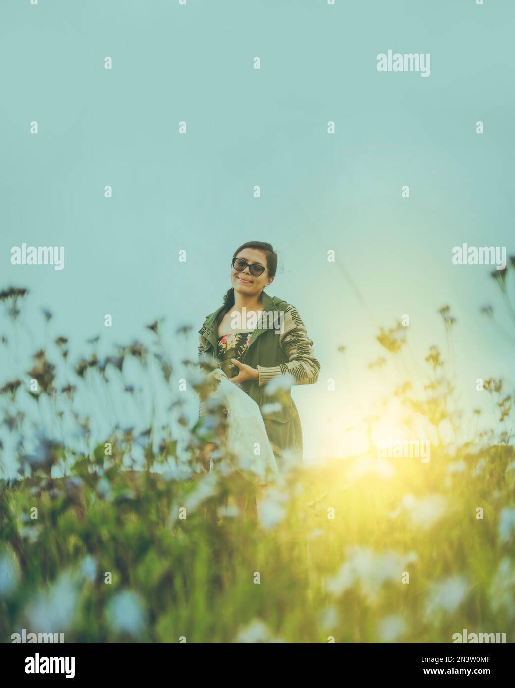 Ritratto di una ragazza in occhiali sul campo, carina ragazza latina sorridente sul campo al tramonto Foto Stock