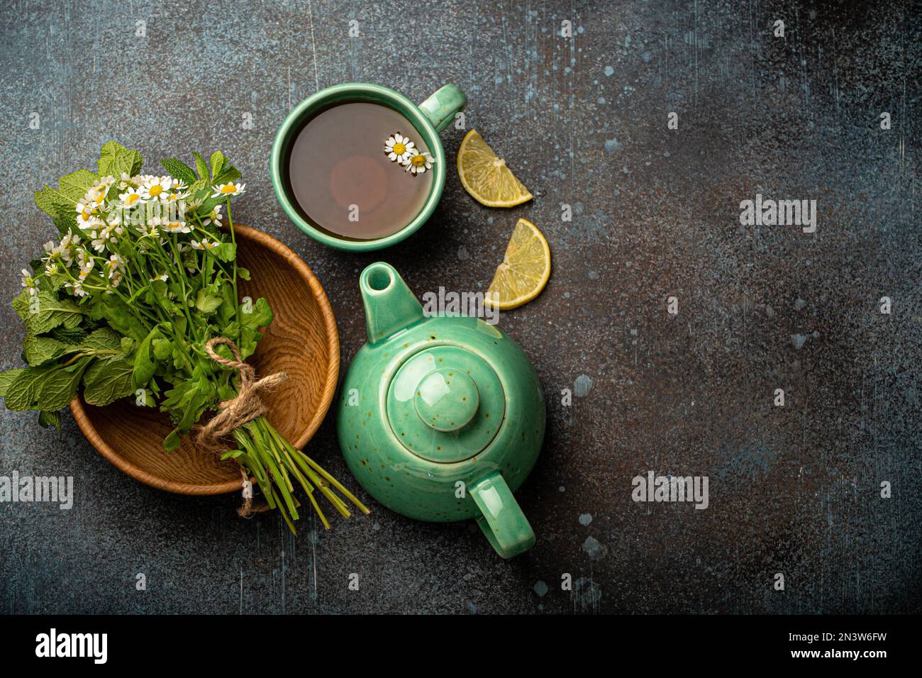 Tè alle erbe con erbe e fiori medici freschi, tisana, tisana e bouquet di fiori freschi e erbe curative vista dall'alto su sfondo di pietra Foto Stock