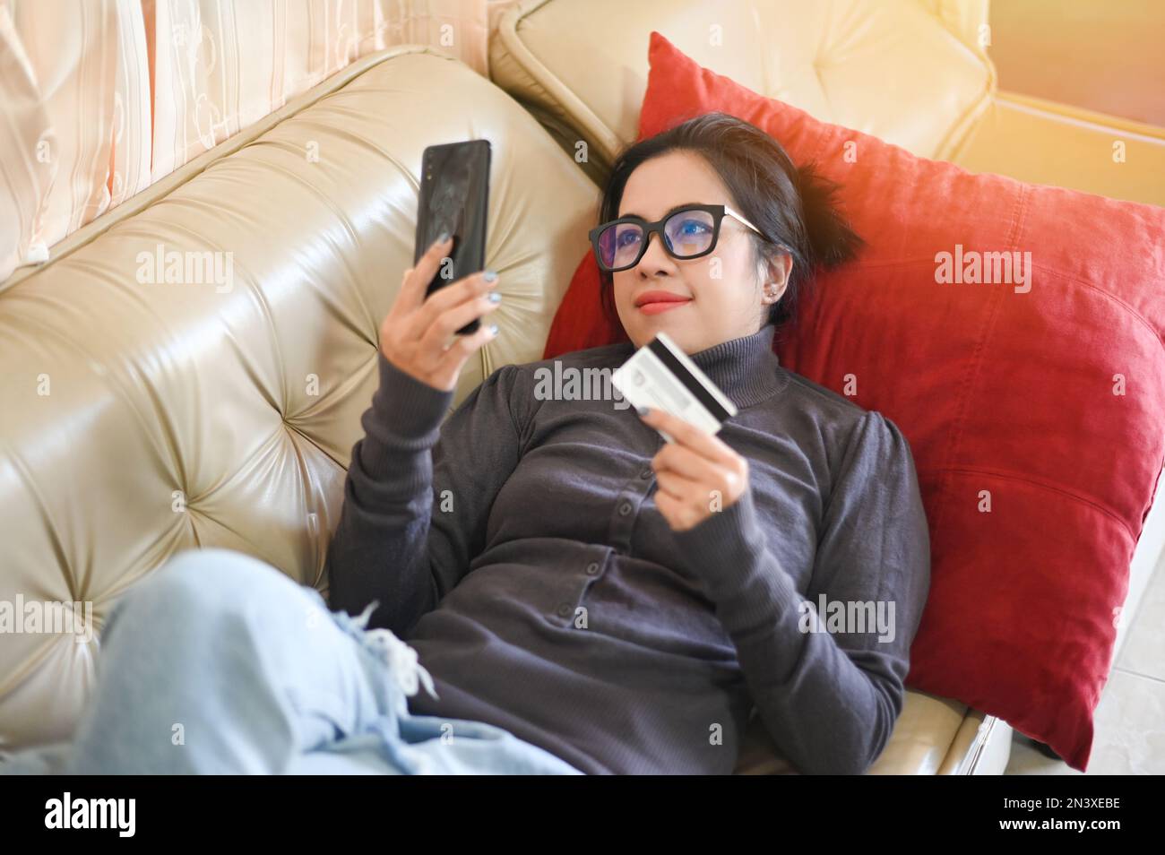donna shopping online, donne relax a casa online shopping sito web su smartphone facile e-commerce online negozio pagare con carta di credito asian femmina hap Foto Stock