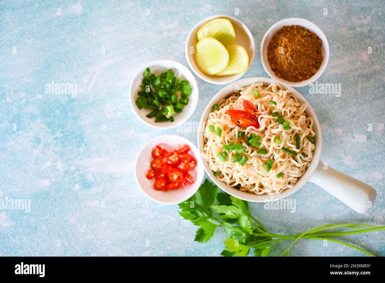 cottura istantanea degli spaghetti gustoso mangiare con il recipiente, spaghetti con verdure primavera cipolla limone lime lattuga sedano e peperoncino su cibo da tavolo, spaghetti sou Foto Stock