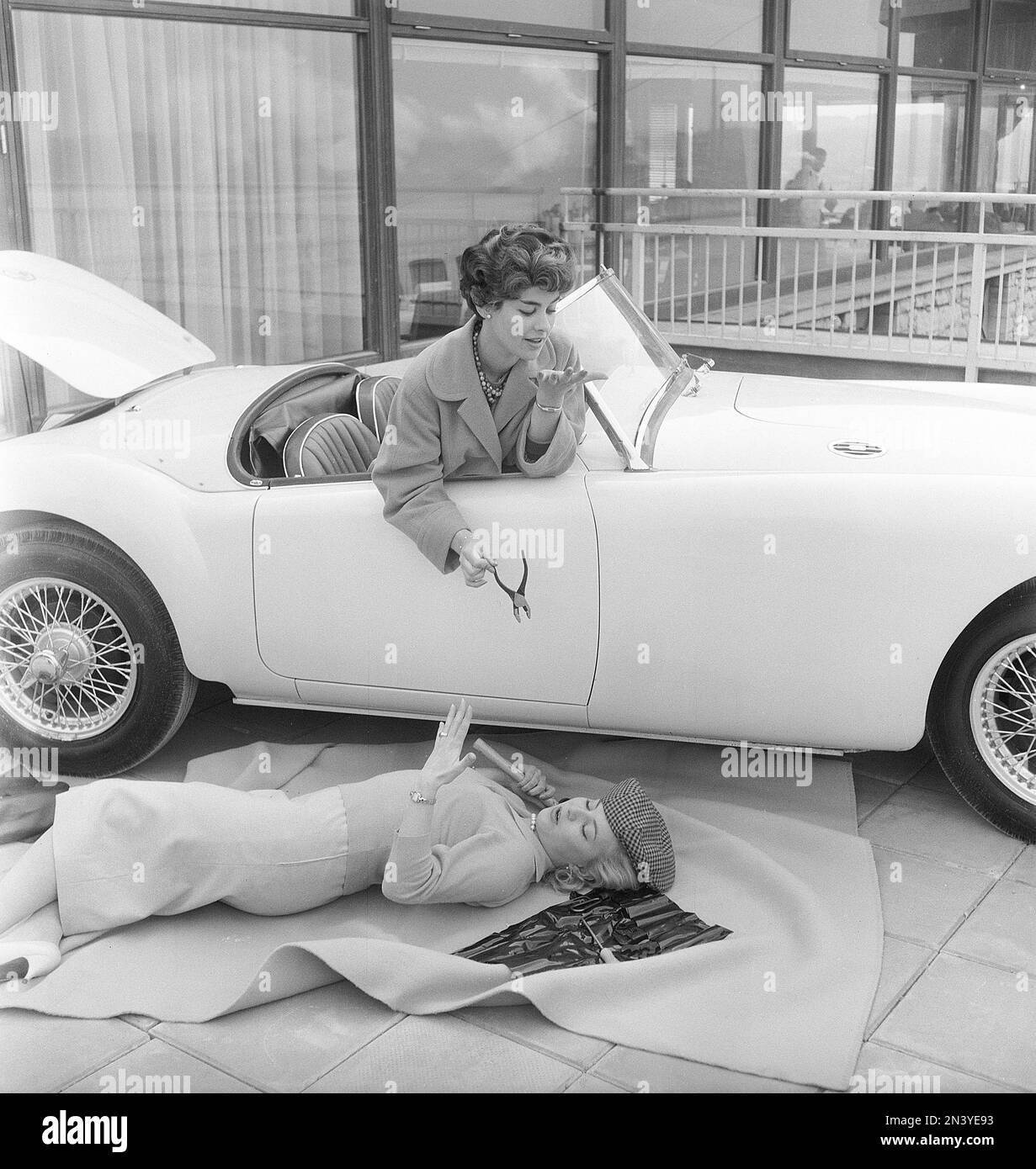 Guida in 1950s. Una scena organizzata con due donne che è visto dentro e fuori da una sportscar. Svezia 1953. rif BX94-11 Foto Stock