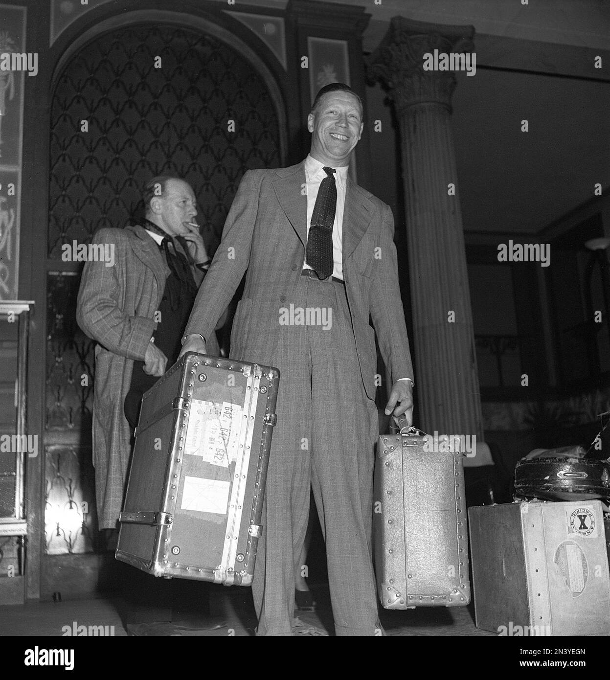 George Formby. Cantante inglese, attore conosciuto come l'uomo ukulele. 1904-1961. Era l'attore britannico più alto pagato 1940. Nella foto, durante il suo soggiorno a Stoccolma in Svezia, ha fatto il check-in al Grand Hotel, dove ha soggiornato con sua moglie. 1946 rif. T137-1 Foto Stock