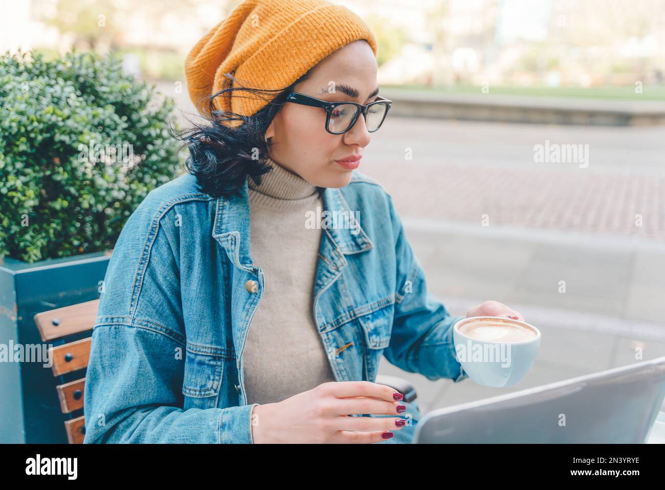 donna infelice studente e imparare formazione a distanza corso di studio lavoro e bere caffè nel bar . Foto Stock