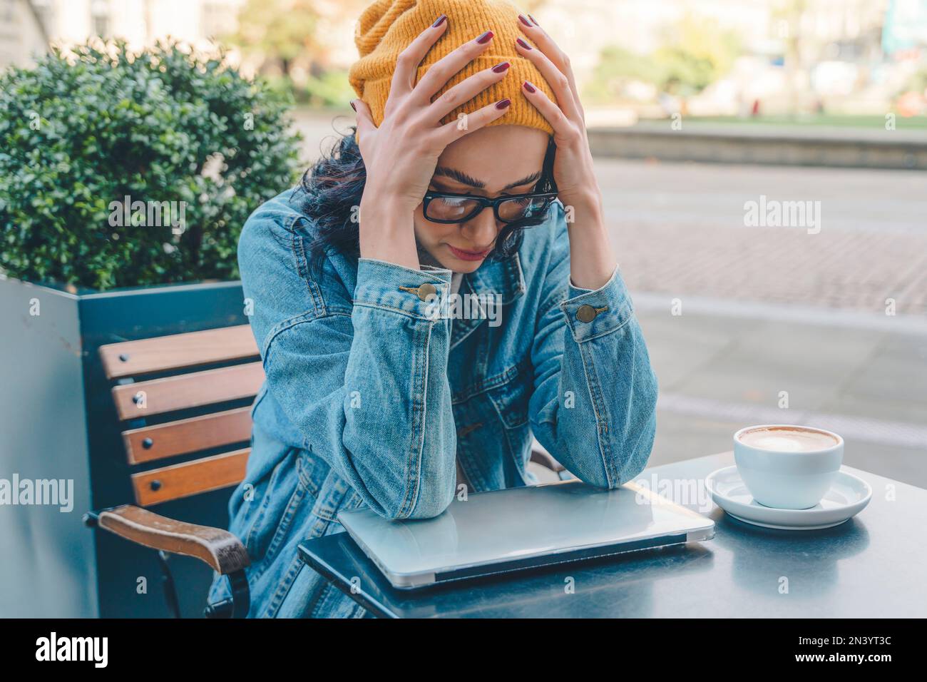 donna infelice studente e imparare formazione a distanza corso di studio lavoro e bere caffè nel bar . Foto Stock