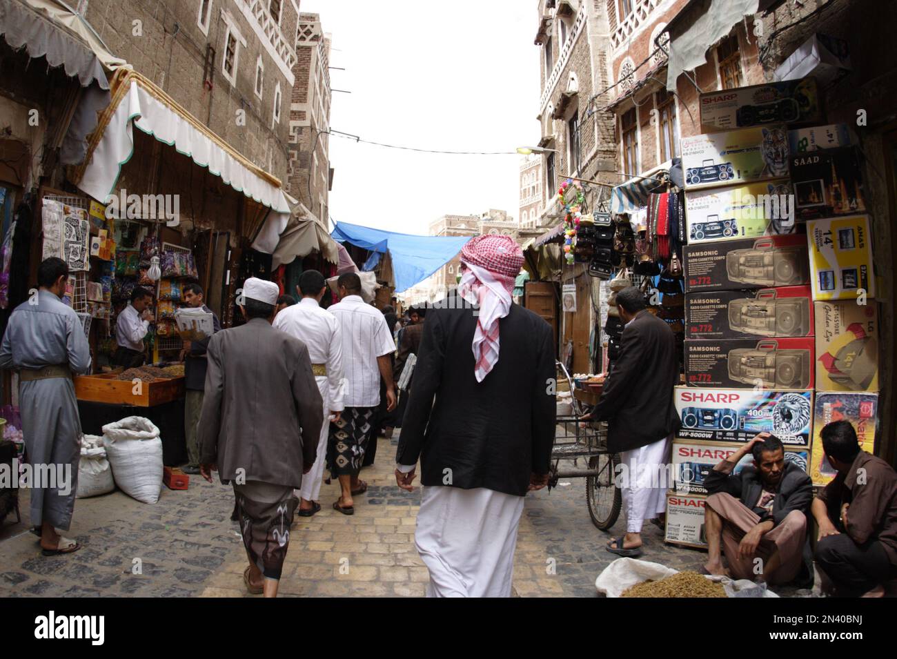 Gli amanti dello shopping passeggiando attraverso gli stretti vicoli vicino a Bab al Yaman, la Città Vecchia, Sanaa, Yemen Foto Stock