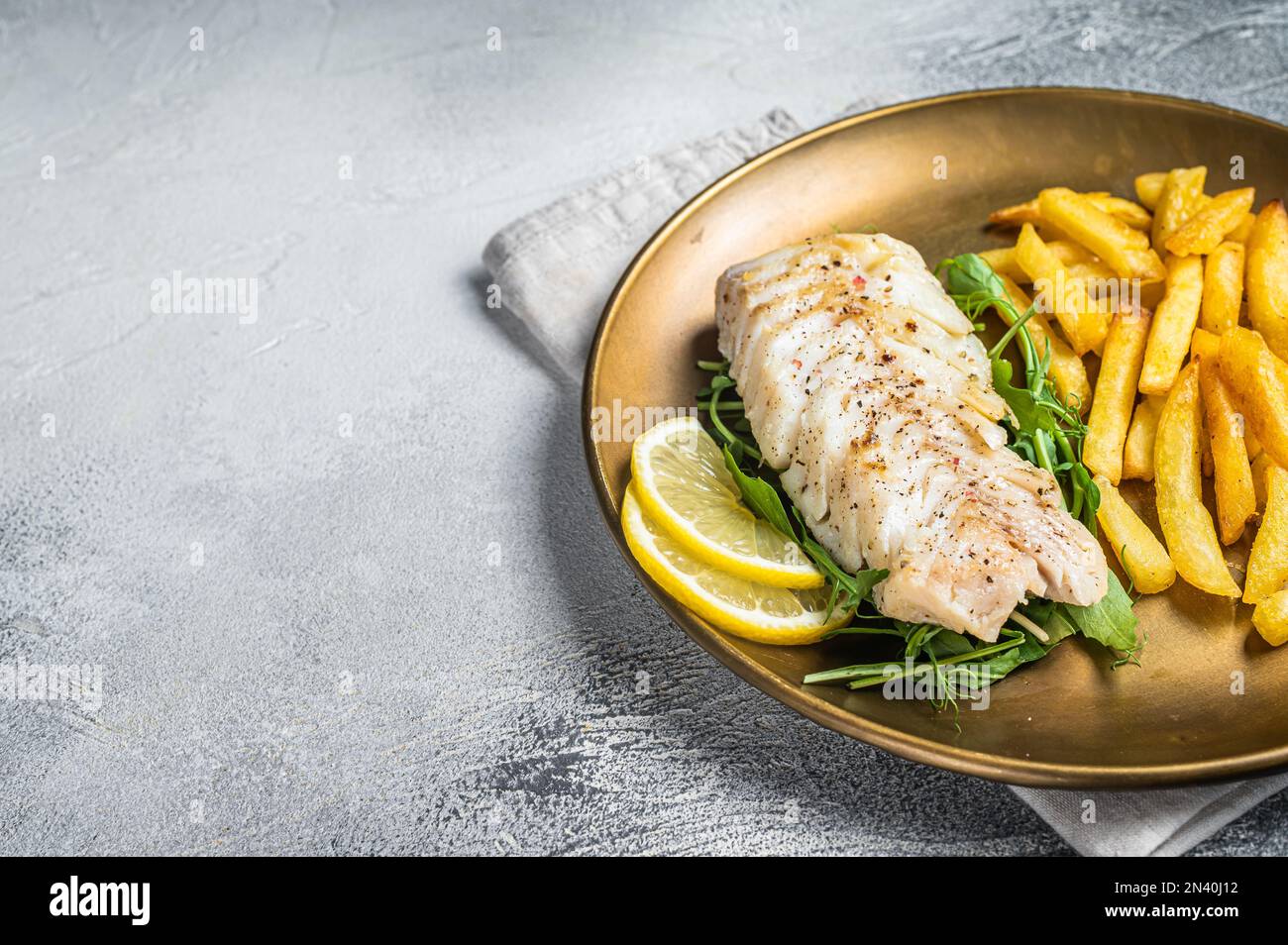 Filetto di merluzzo fritto servito con patatine fritte. Sfondo bianco. Vista dall'alto. Spazio di copia. Foto Stock