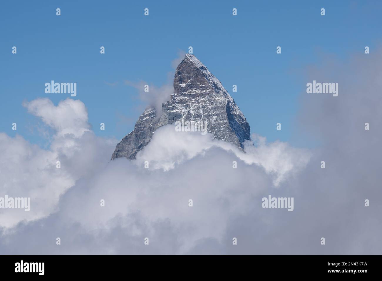 Una vista aerea della cima del Monte Cervino roccioso coperto da bianche e soffici nuvole Foto Stock
