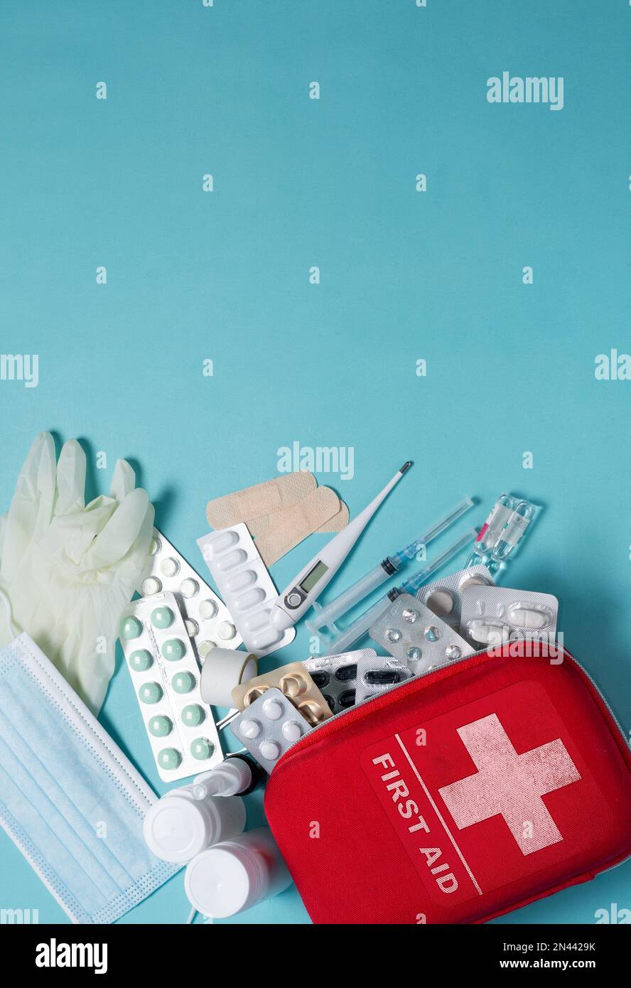 Banchiere verticale per kit di pronto soccorso su sfondo blu. Gli elementi del kit di pronto soccorso Foto Stock