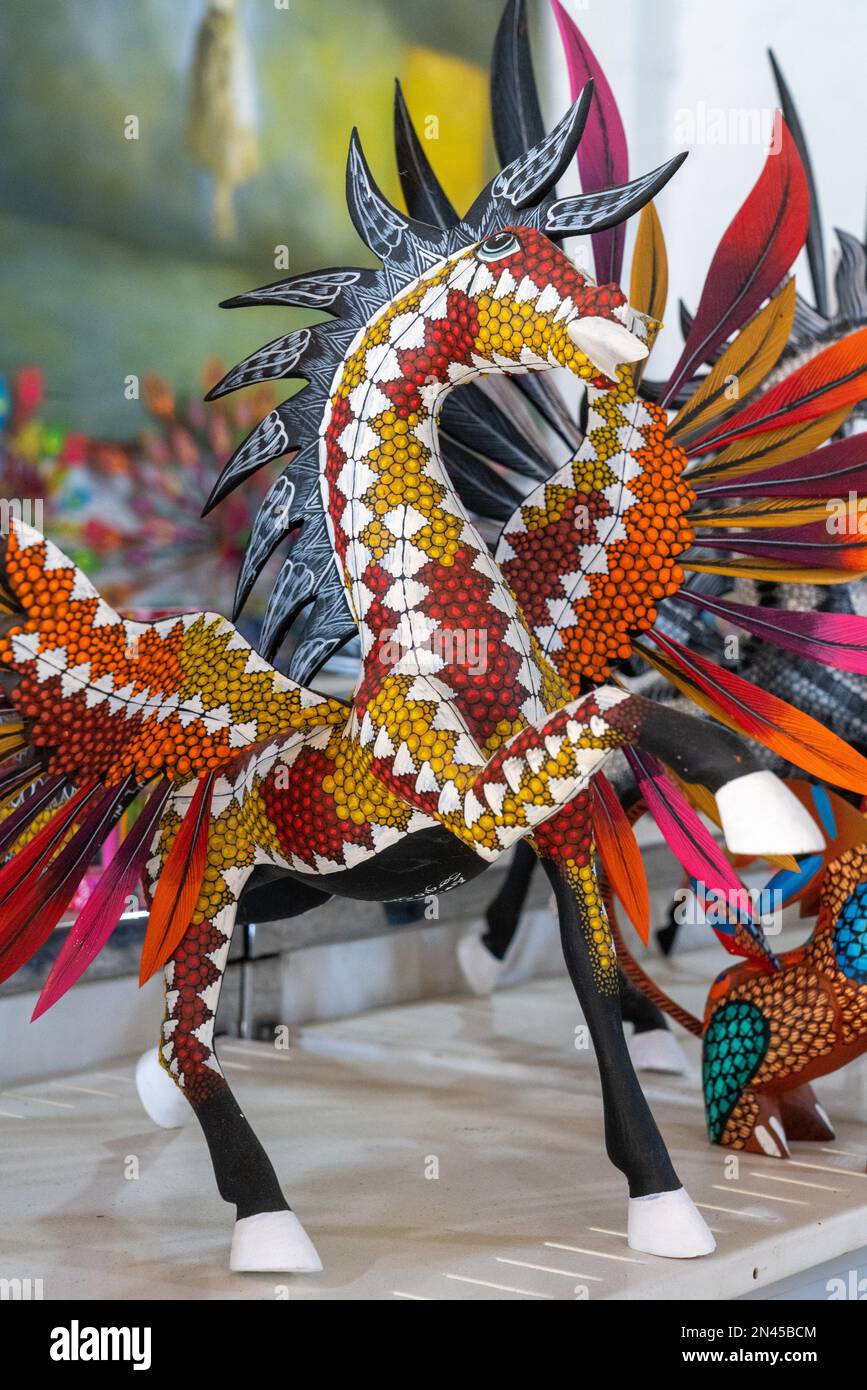 Un'alebrije a cavallo alato in un negozio/laboratorio artigianale a San Antonio Arrazola, Oaxaca, Messico. Alebrijes sono creature colorate dipinte relative a. Foto Stock