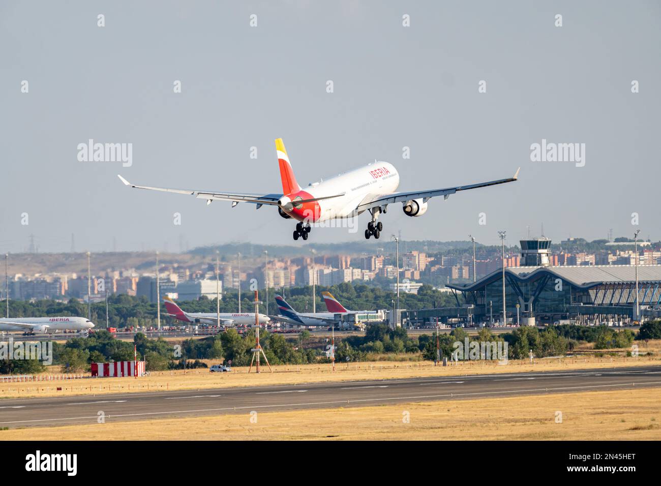 Iberia airbus bianco, rosso e giallo A330-302 A333 con numero di immatricolazione EC-MAA e carrello abbassato per l'atterraggio all'aeroporto di Barajas, Madrid. Foto Stock