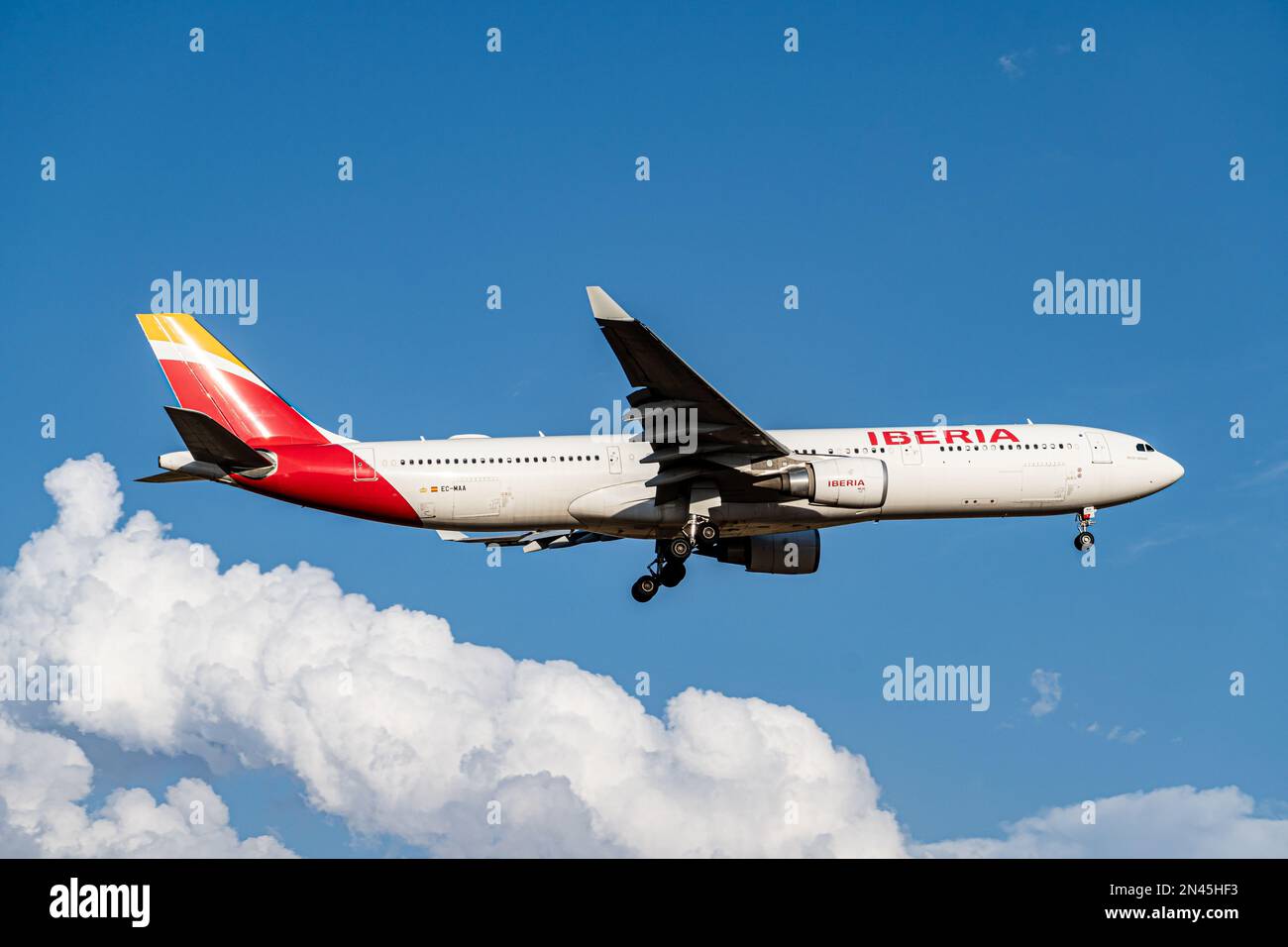 Iberia airbus bianco, rosso e giallo A330-302 A333 con numero di immatricolazione EC-MAA e carrello abbassato per l'atterraggio all'aeroporto di Barajas, Madrid. Foto Stock