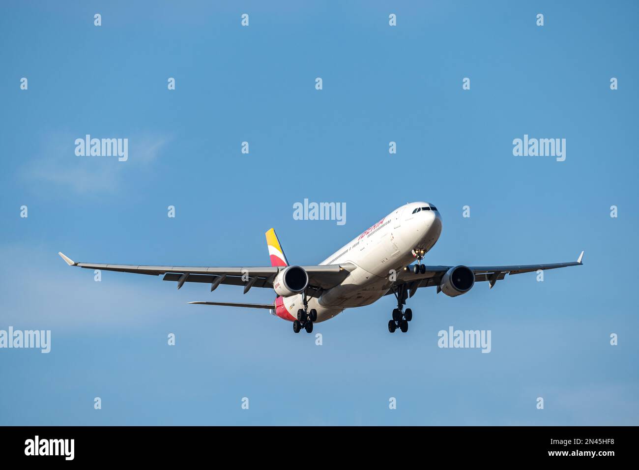 Iberia airbus bianco, rosso e giallo A330-302 A333 con numero di immatricolazione EC-MAA e carrello abbassato per l'atterraggio all'aeroporto di Barajas, Madrid. Foto Stock