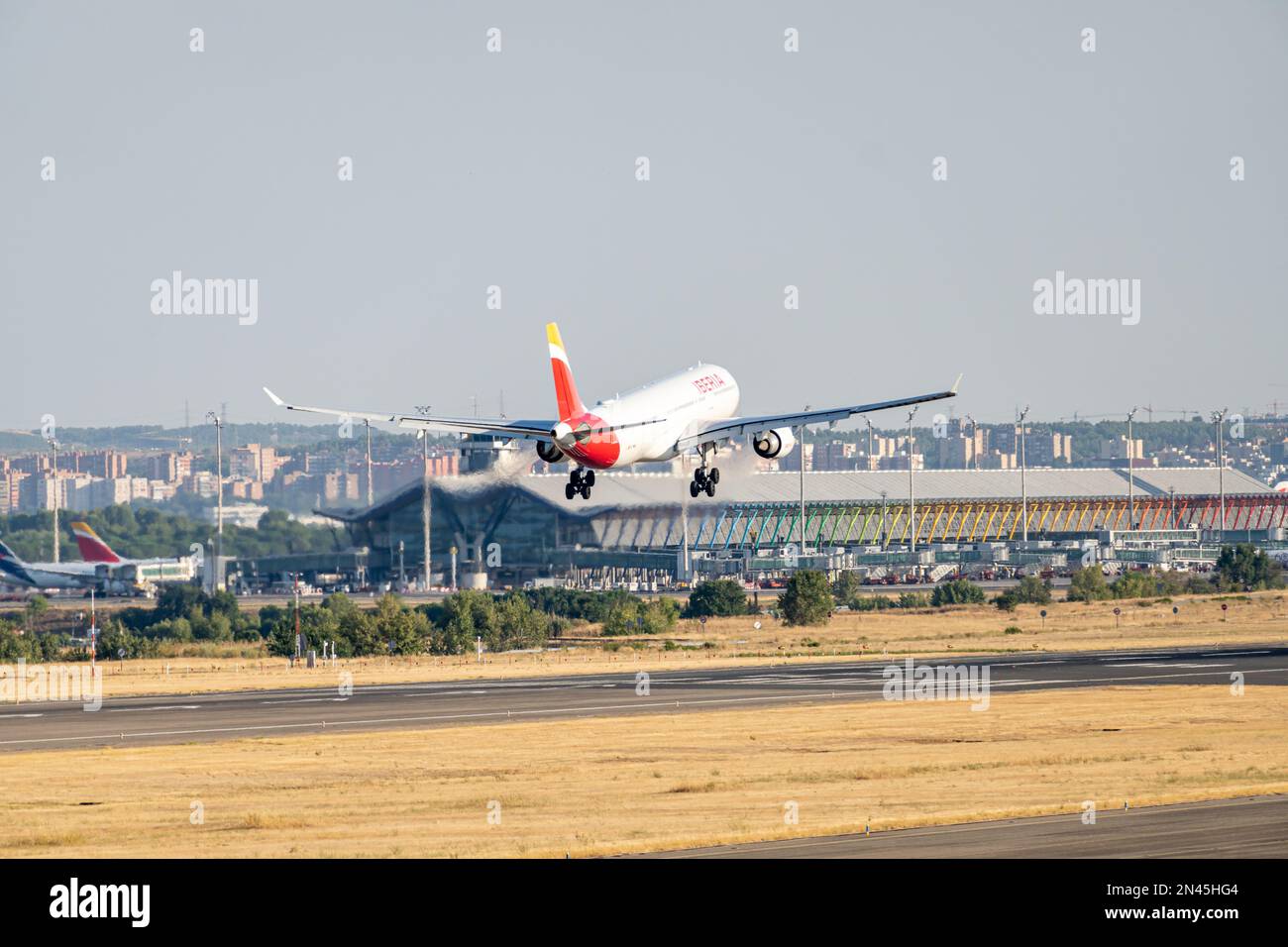 Iberia airbus bianco, rosso e giallo A330-302 A333 con numero di immatricolazione EC-MAA e carrello abbassato per l'atterraggio all'aeroporto di Barajas, Madrid. Foto Stock