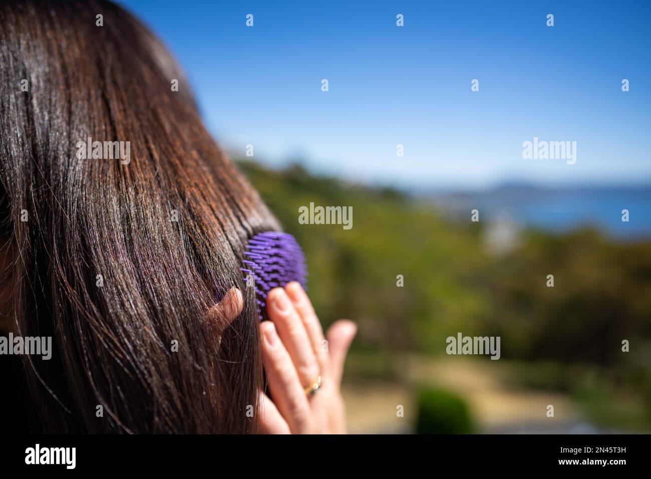 Bella ragazza spazzolando i capelli, modello styling capelli neri pronti per uscire ad un evento in australia Foto Stock