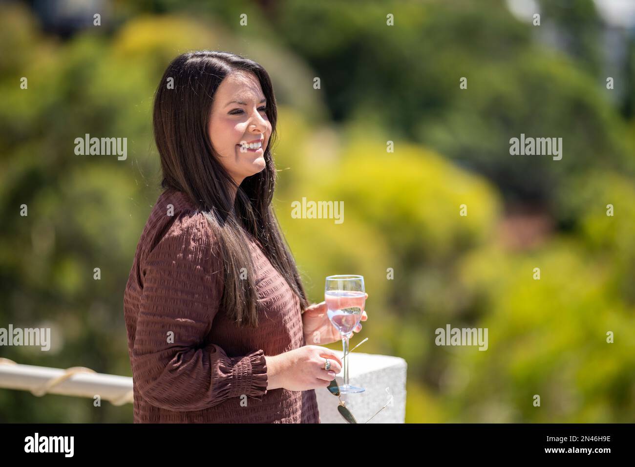 bella signora su un balcone che ha un drink a hobart australia in estate Foto Stock