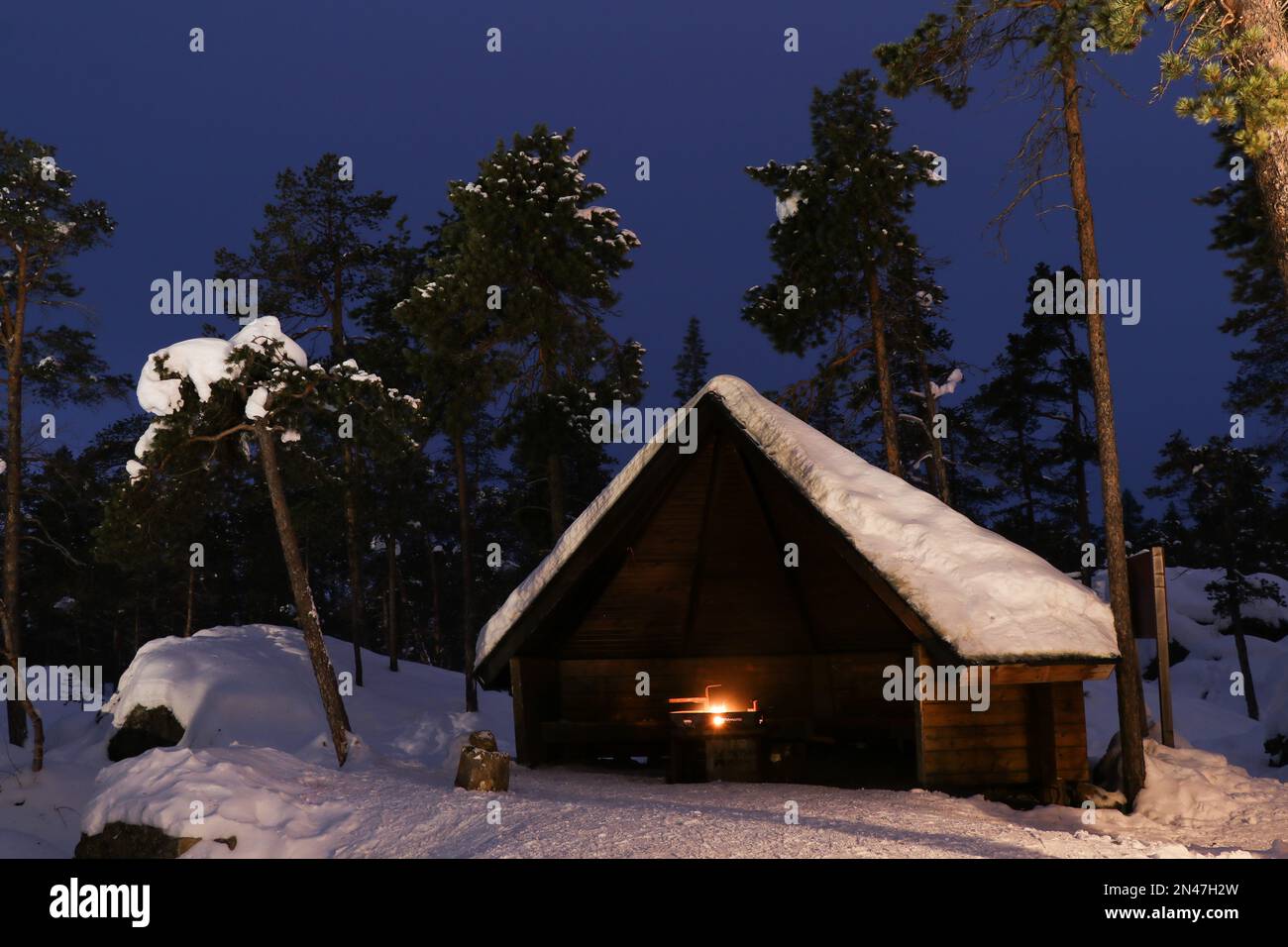 Cabina nel finale inverno selvaggio con un fuoco da campo Foto Stock