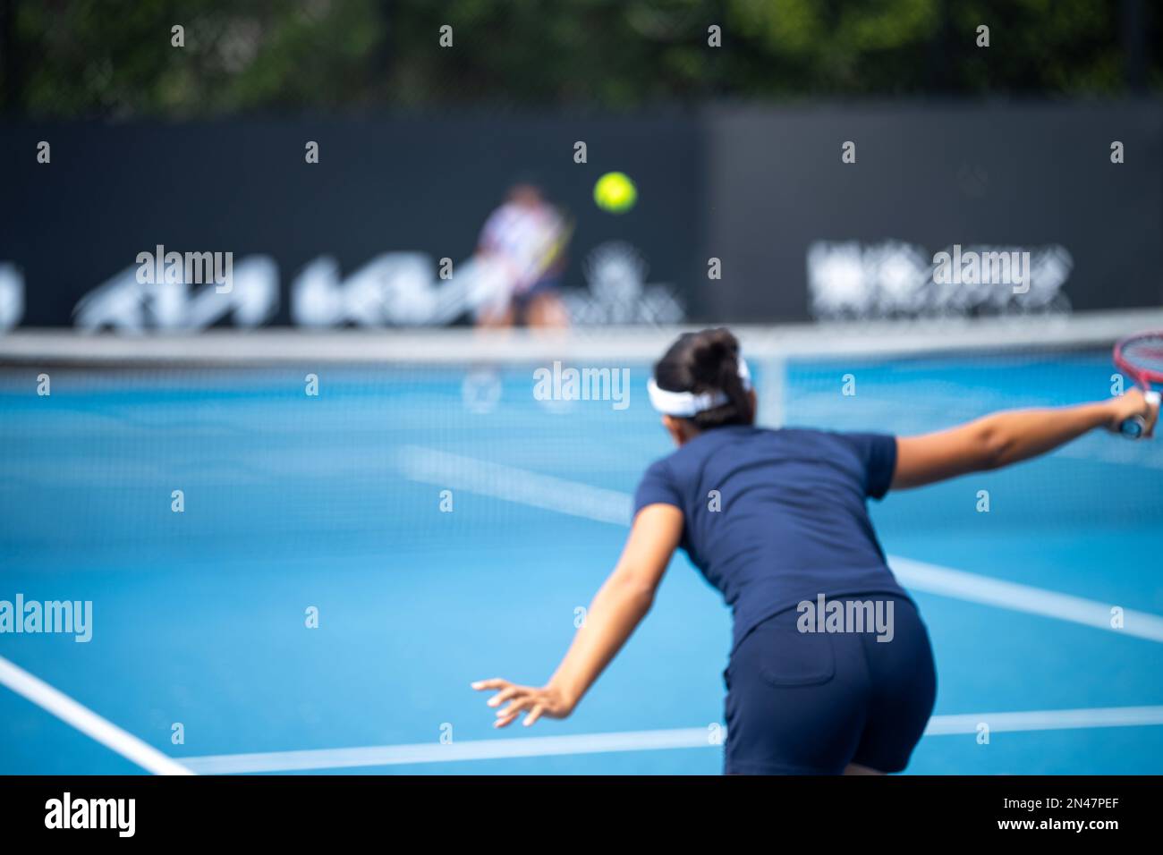 Tennista che serve in una partita di tennis, con guida in gamba in una partita di sport Foto Stock