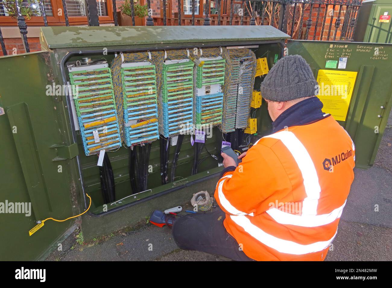 MJ Quinn OpenReach ingegnere appaltatore di telecomunicazioni, che lavora su un armadio aperto di strada, Warrington, Cheshire, NW Inghilterra, Regno Unito, WA4 Foto Stock