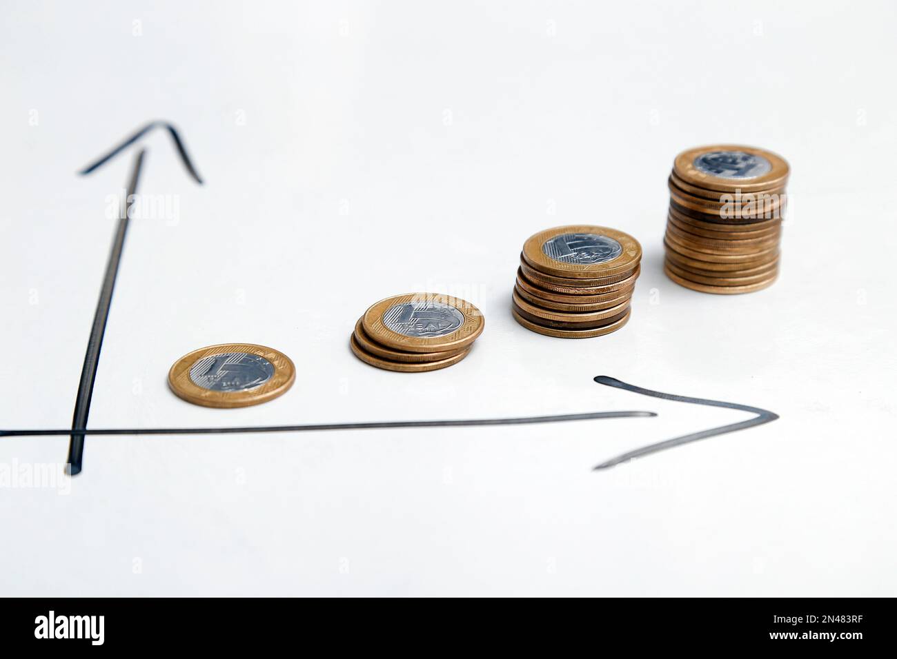 monete su sfondo bianco e frecce direzionali che indicano la crescita del tempo e dei profitti - finanza, reddito e interesse concetto Foto Stock