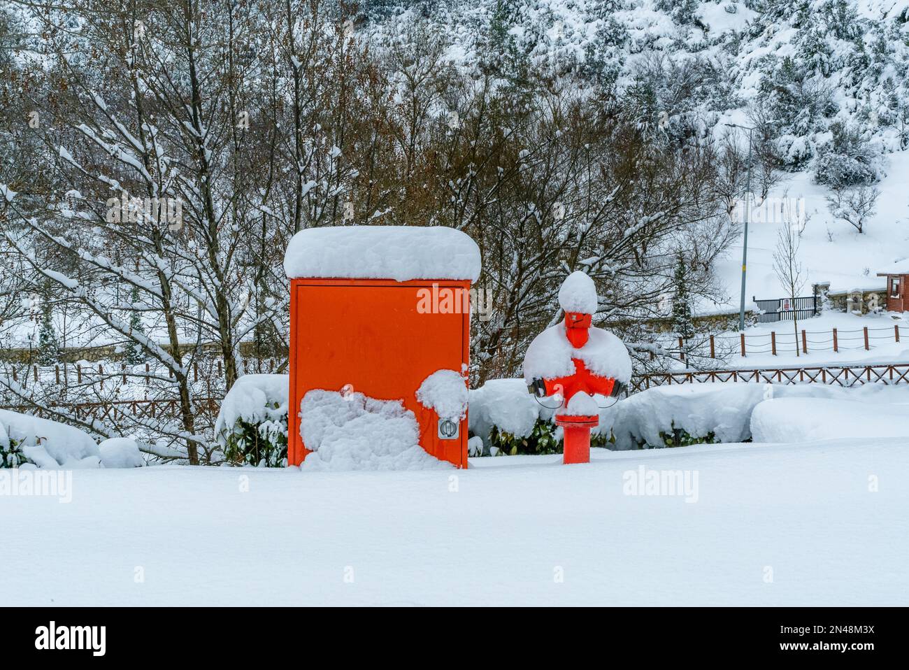 Estintore a idrante rosso per strada. Coperto di neve. Foto Stock