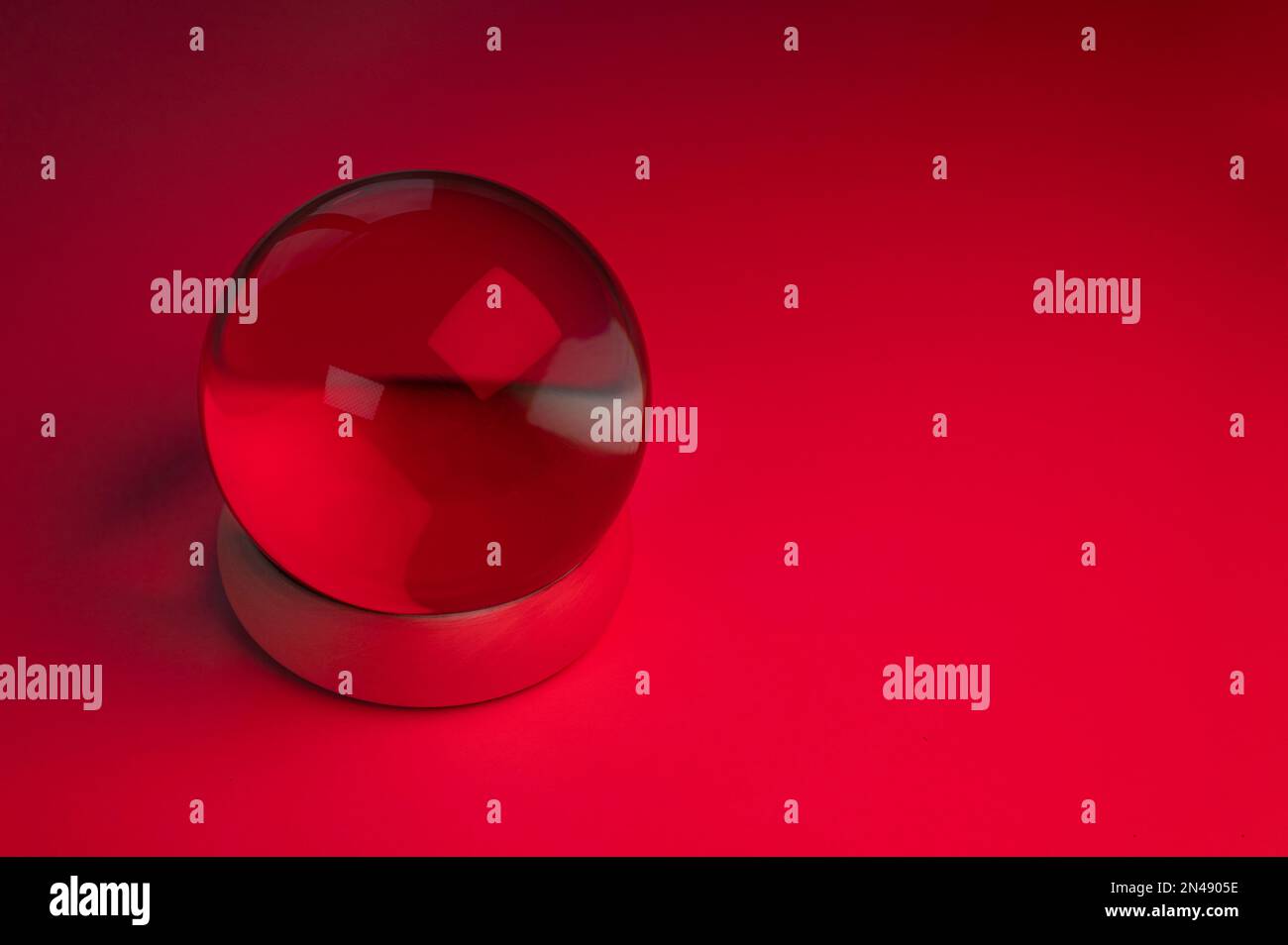 Sfera di cristallo di vetro su un tavolo con luce rossa Foto Stock