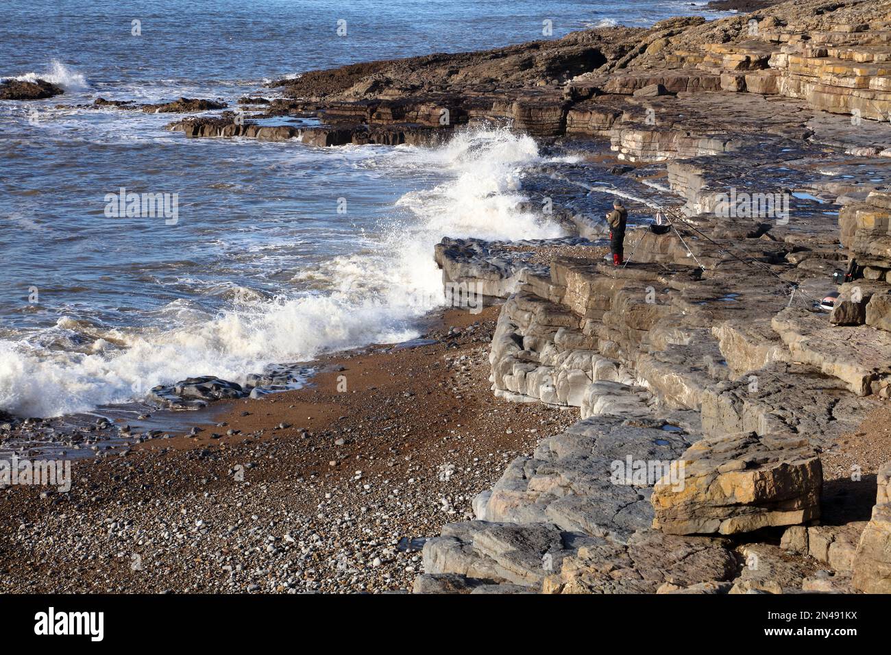 Una bella giornata fuori per fare un po' di rilassante pesca nella roccia in una piccola baia privata sulla costa nel canale di Bristol. Foto Stock