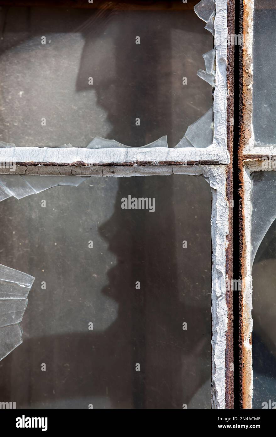 Vetri della finestra rotti con una faccia urlante simile a quella di un essere umano Foto Stock