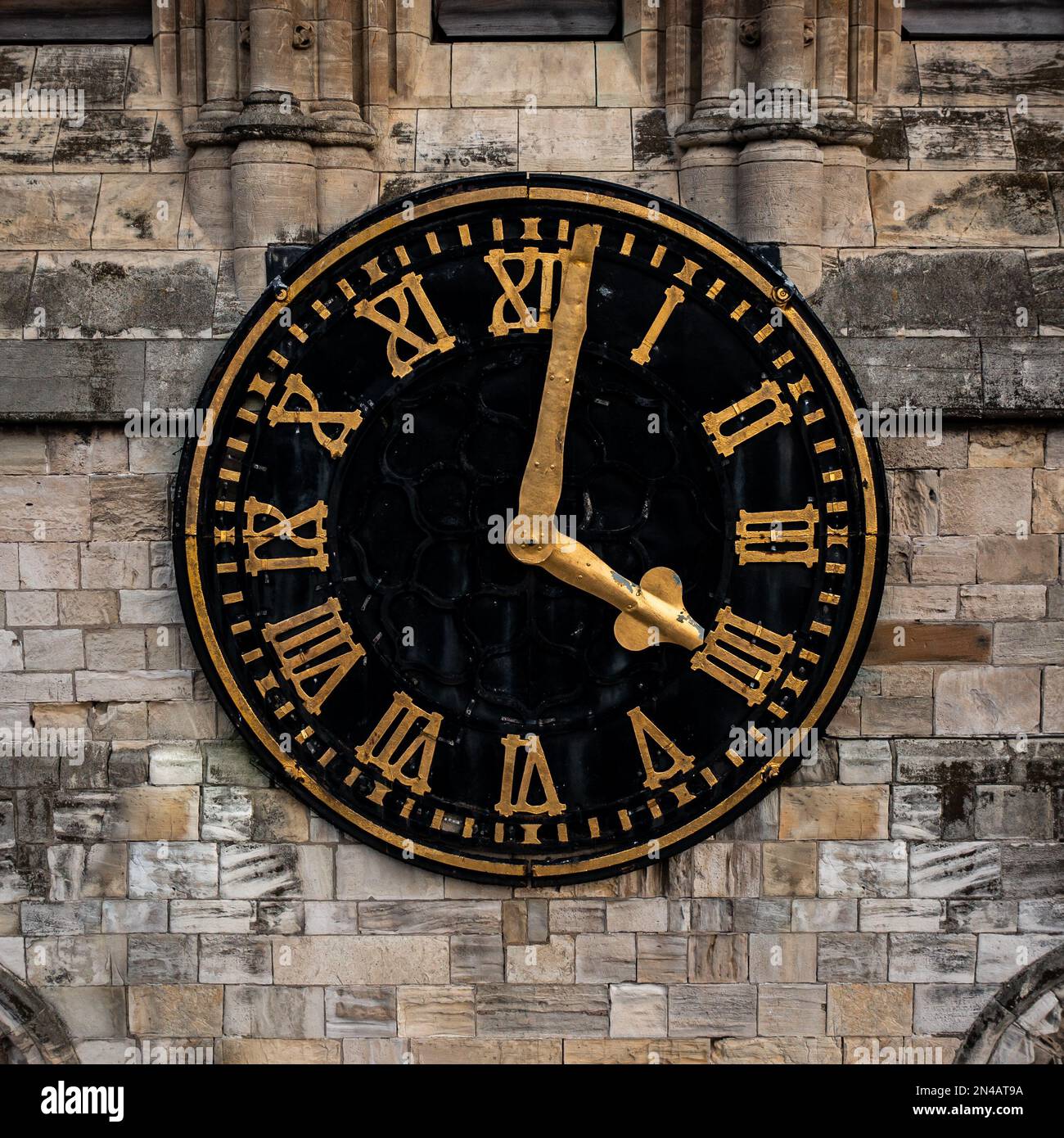 Primo piano del volto e delle mani di un tradizionale orologio da chiesa su una torre dell'orologio in una cornice quadrata Foto Stock