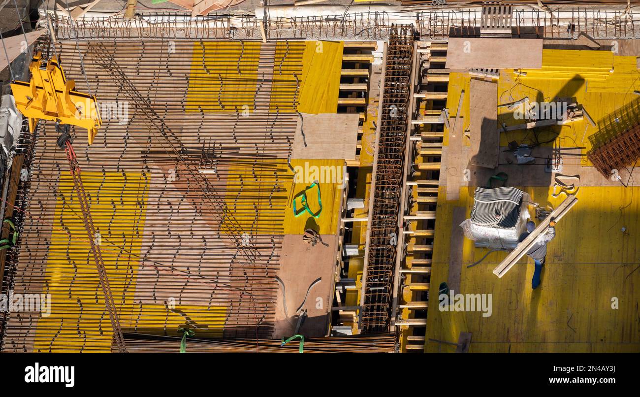 Vista dall'alto di piastre di fondazione in cemento e acciaio in un cantiere di un edificio di uffici. Foto Stock