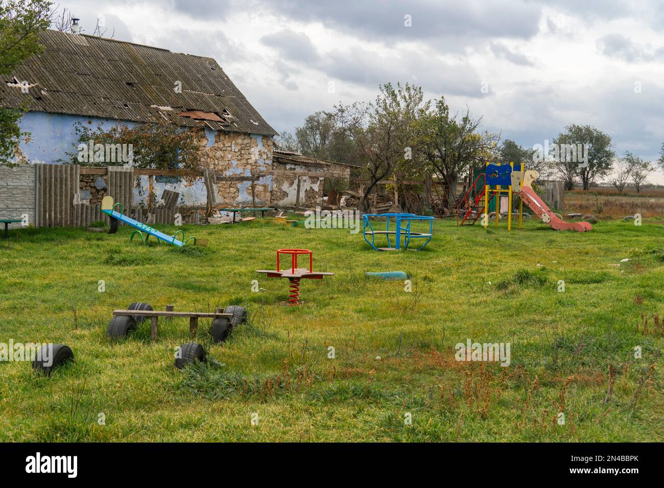 Campagna. Parco giochi vuoto danneggiato dal bombardamento. Guerra in Ucraina. Invasione russa dell'Ucraina. Terrore della popolazione civile. Crimini di guerra Foto Stock