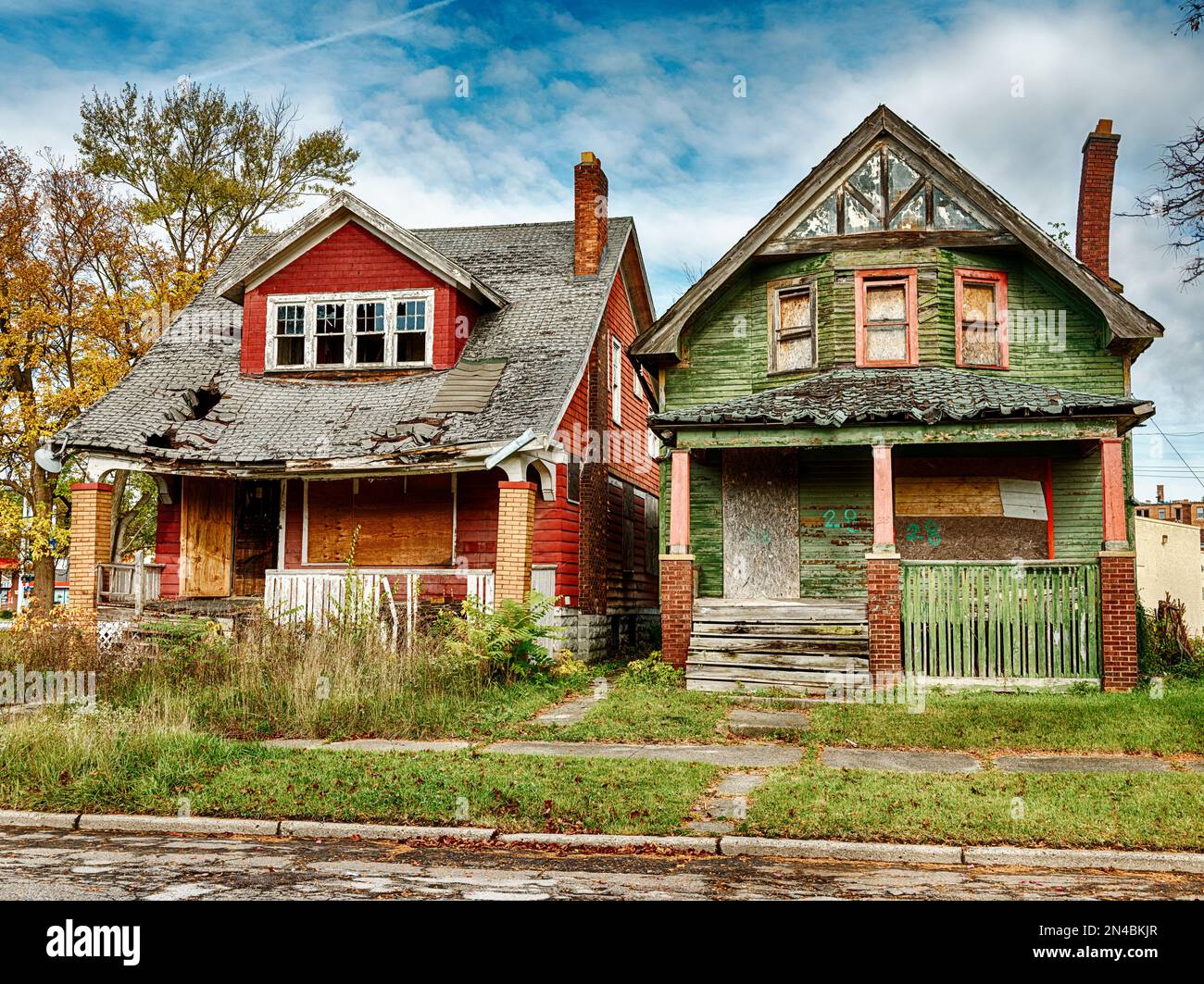 Una casa verde e una rossa sono abbandonate e salite a bordo nella zona di Highland Park di Detroit. Foto Stock