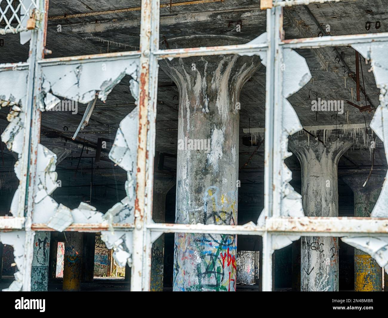 Il vetro vuoto nelle finestre si trova di fronte ad un impianto di maniacizzazione di automobili vuoto a Detroit, Michigan. Foto Stock