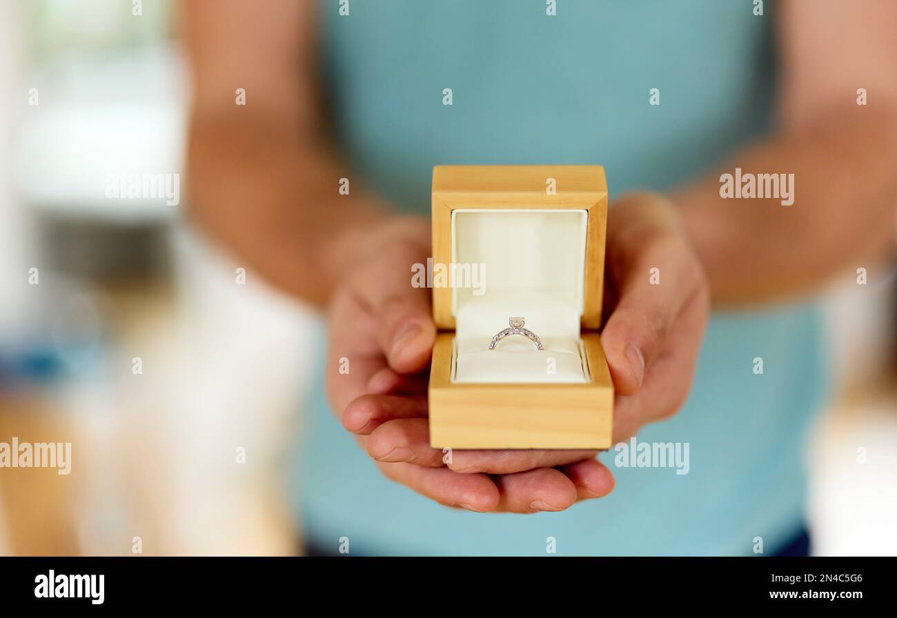 Uomo che tiene in mano e presenta un anello di aggancio scatolato aperto Foto Stock