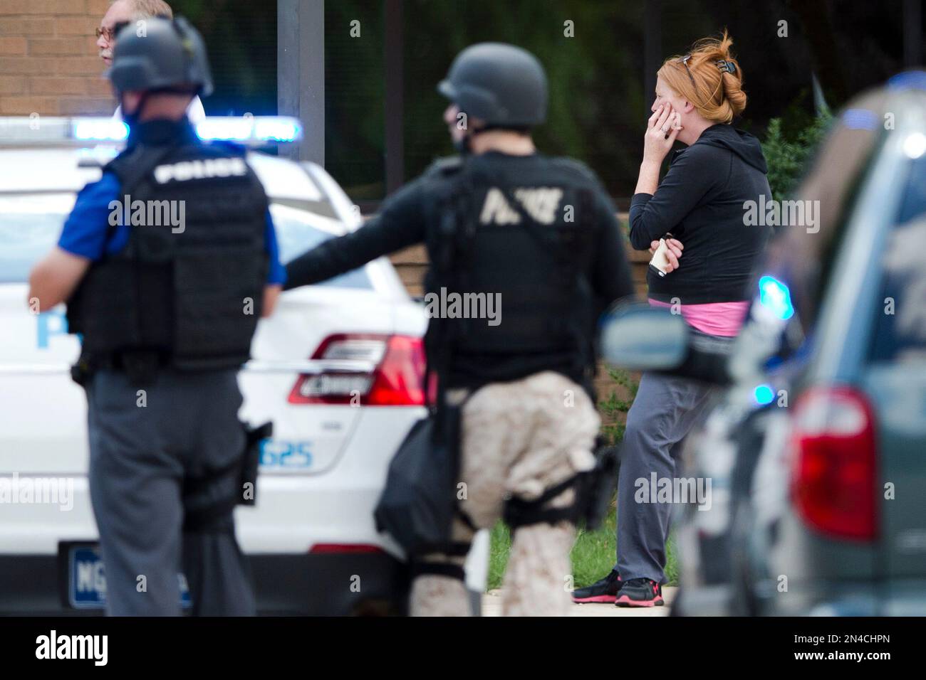 A hospital worker views police activity around the scene of a shooting Thursday, July 24, 2014, at Mercy Fitzgerald Hospital in Darby, Pa. Police in suburban Philadelphia are investigating a shooting at the hospital campus and say they have reports people have been injured and a suspect is in custody. (AP Photo) Foto Stock