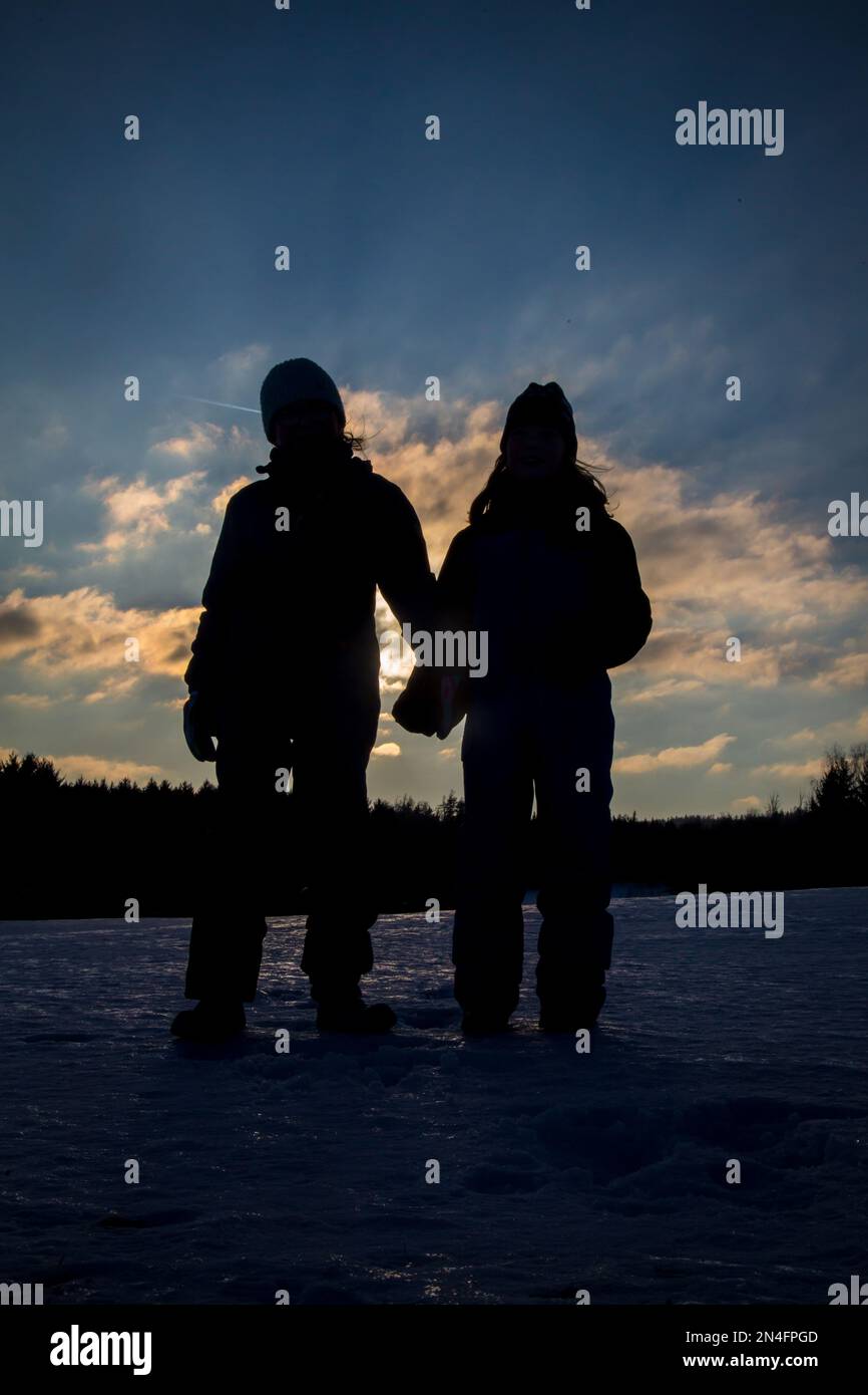 Bambini contro il tramonto, vacanze invernali in Austria Foto Stock