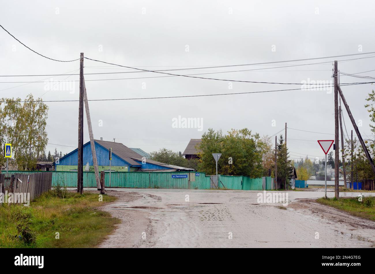 Bagnare una forchetta sulla strada senza asfalto nel nord del villaggio di Yakut di suntar pioggia giorno grigio. Foto Stock