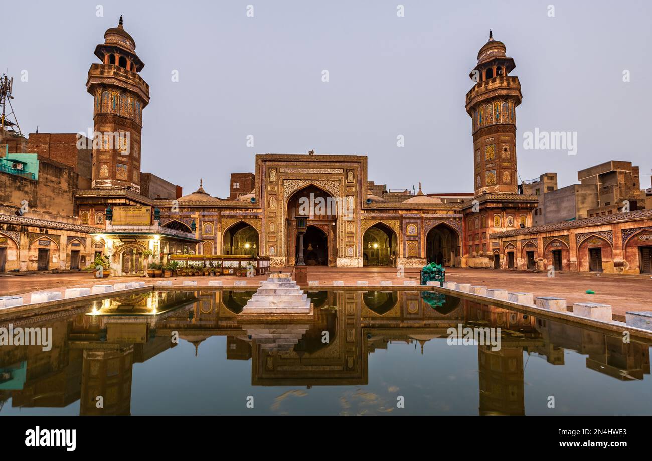 Riflessione della moschea di Wazir Khan in uno stagno presente nel suo cortile Lahore, Pakistan Foto Stock