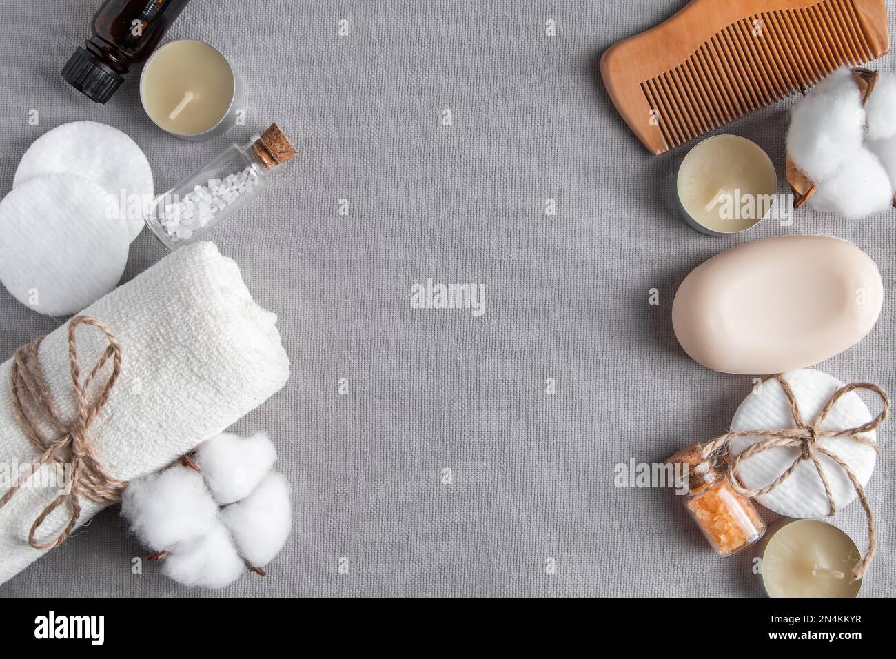 Accessori spa e cosmetici su sfondo grigio texture. Asciugamano, sapone, spazzola per capelli, olio essenziale. Prodotti naturali ecologici per il benessere, senza sprechi. C Foto Stock