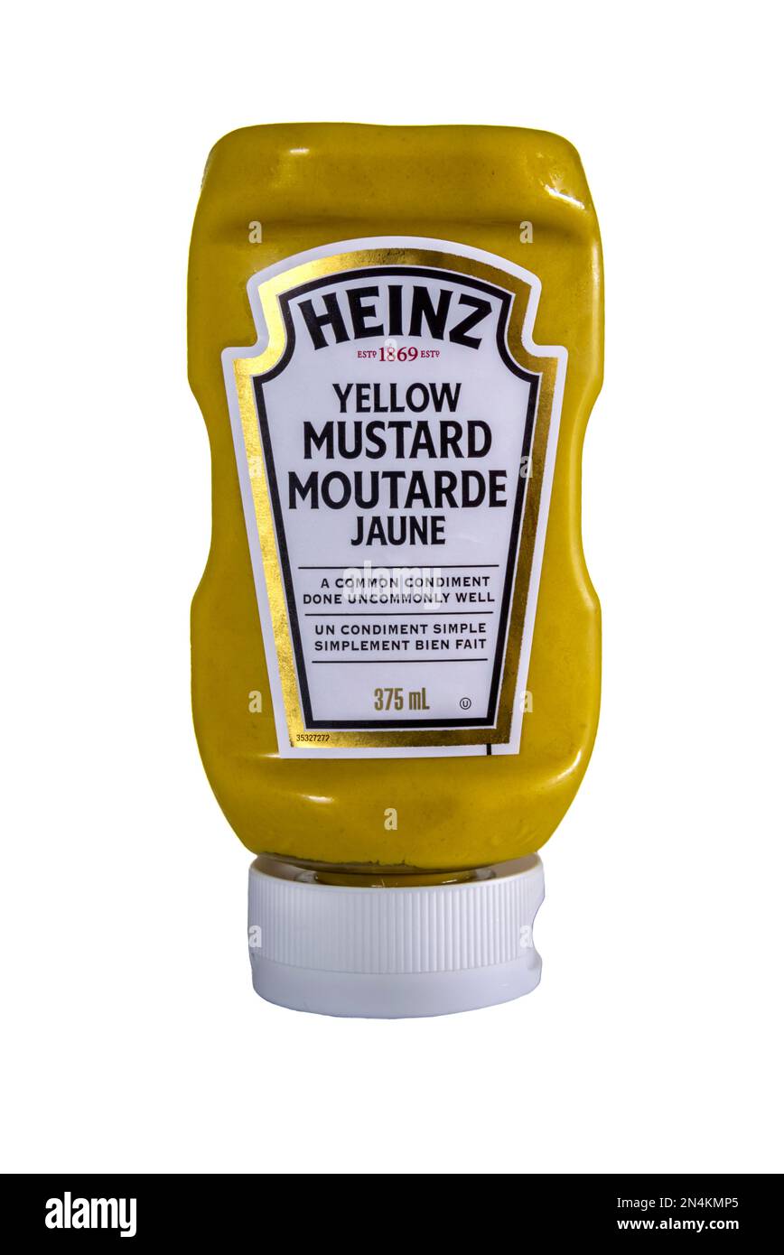 Una bottiglia squeezy di senape gialla venduta in Canada da Heinz. Con un'etichetta bilingue. Foto Stock