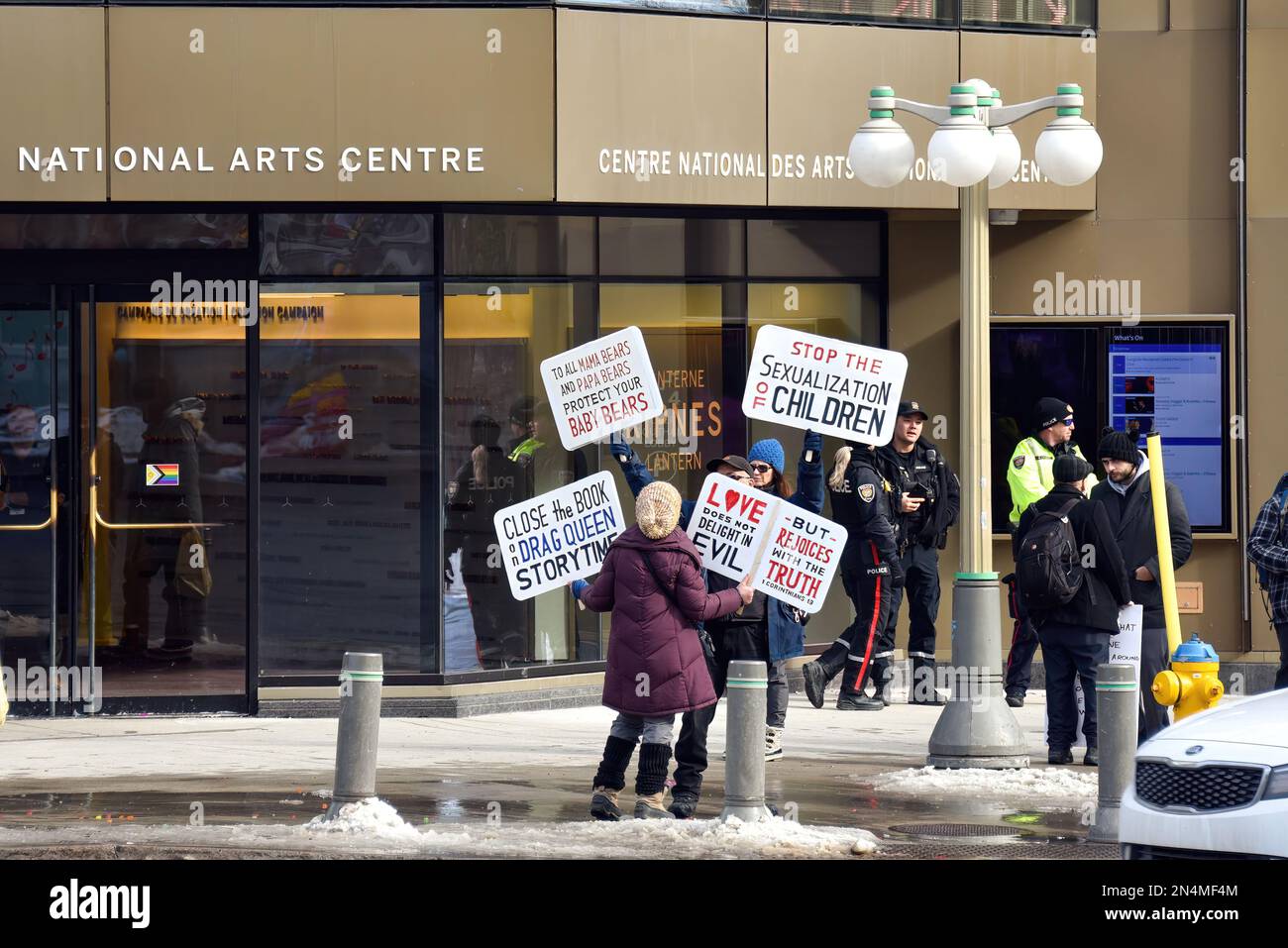 Ottawa, Canada - 8 febbraio 2023: Persone che detengono cartelli che protestano per l'evento Drag Story Time per bambini tenutosi presso il National Arts Centre. Gli artisti del drag China Doll e Cyril Cinder leggono storie ai bambini come parte dell'evento Capital Pride Winterlude. Anche un gruppo di contro-manifestanti si è mostrato a sostegno dell'evento. C'era anche una presenza di polizia per garantire la pace. Foto Stock