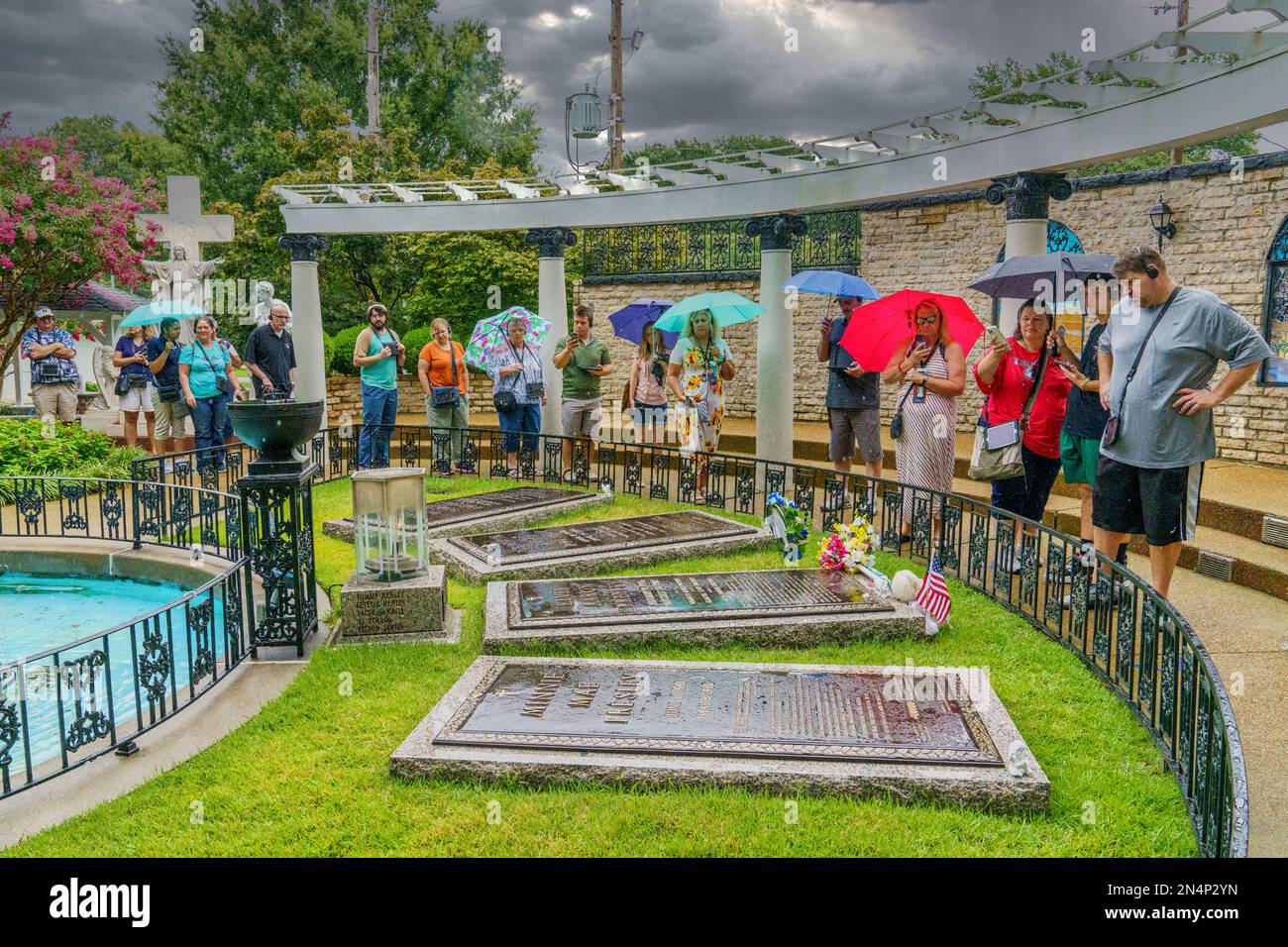 I visitatori si rendono omaggio alle tombe della famiglia Presley nel Meditation Garden di Graceland, la casa di Elvis Presley a Memphis, Tennessee. Foto Stock